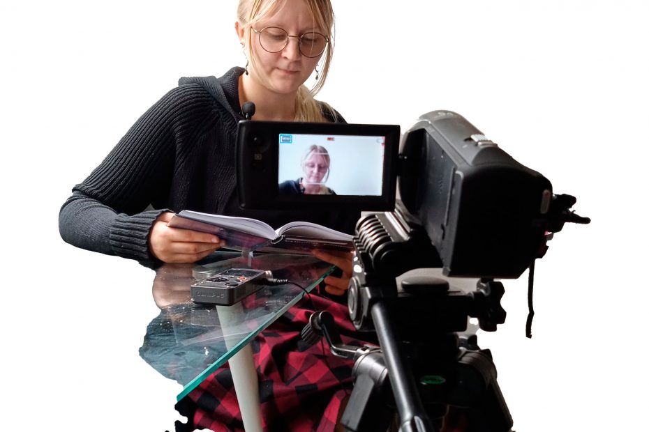 Iiris lukee Sirimaan Salaisuus -kirjaa videokameran edessä